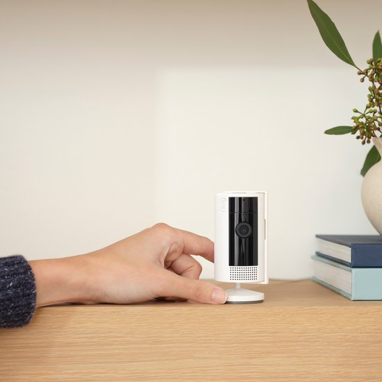 Ring Indoor Cam wit naast een hand voor een indruk van het formaat