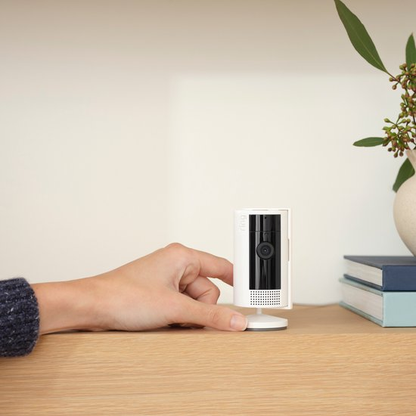 Ring Indoor Cam wit naast een hand voor een indruk van het formaat