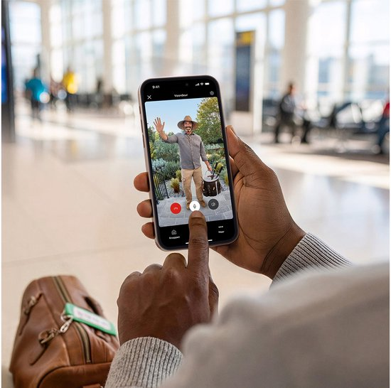 Persoon bekijkt een bezoeker bij de voordeur via de Ring-app op een smartphone